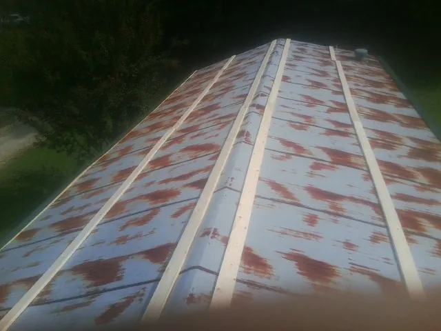 Rusted metal roof panels with new wood purlins before replacement — Storm Damage Roof Repair in Longbranch by Roofing Brothers