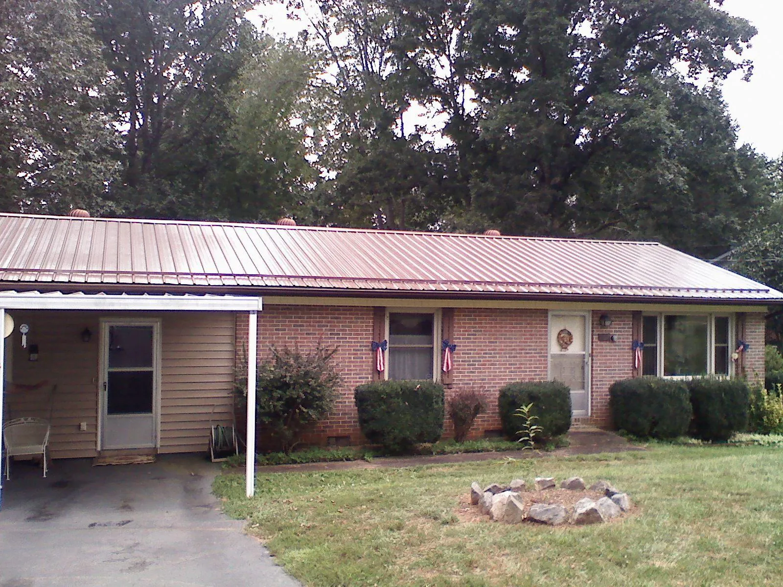 Bronze metal roof and carport on a brick ranch home — Roof Repair work by our crew in Longbranch