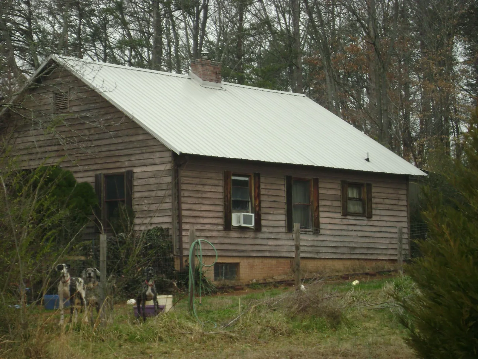 White metal roof on an old wood sided farmhouse, from a Metal Roof Installation job in Longbranch